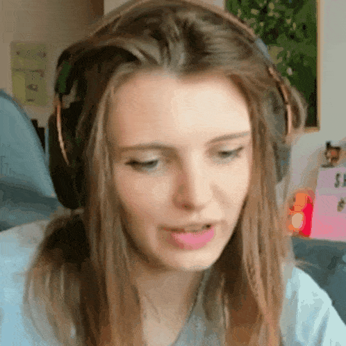 a close up of a woman wearing headphones making a funny face