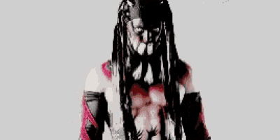 a man with dreadlocks and a bandana on his head is standing in front of a white background .