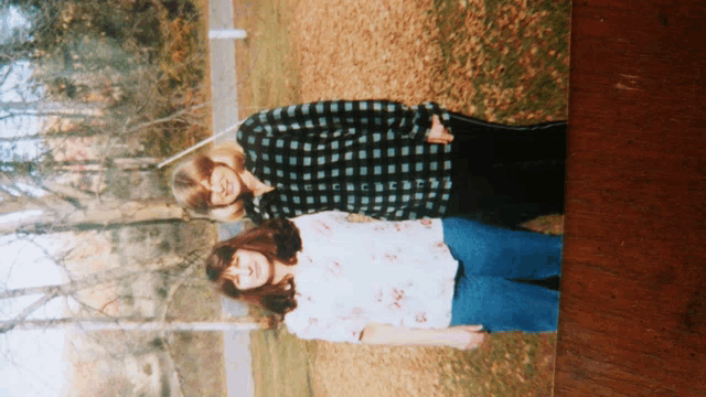 a photo of two women standing next to each other in a park