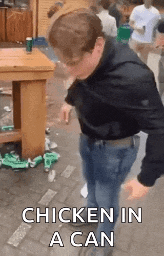 a man is standing in front of a table with the words chicken in a can on the bottom .