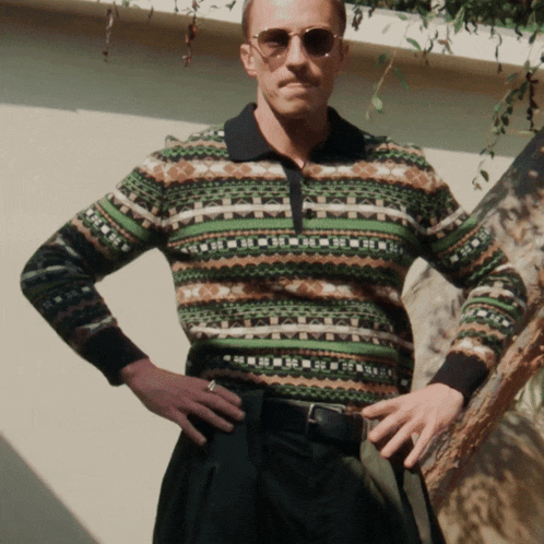 a man wearing sunglasses and a colorful sweater