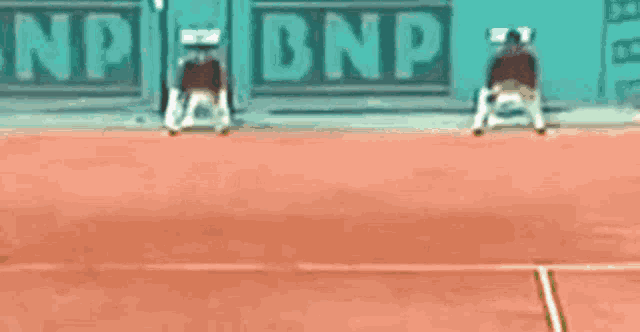 a person playing tennis in front of a banner that says dnp
