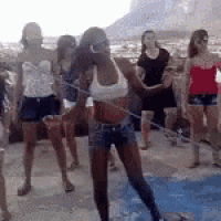 a group of women are standing around a swimming pool .