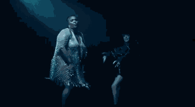 two women are standing next to each other on a stage in front of a crowd .