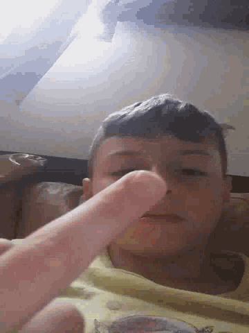 a close up of a person 's face with a finger pointing at it .