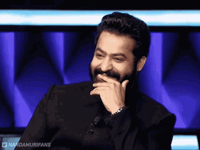 a man with a beard is smiling with nandamurifans written on the bottom
