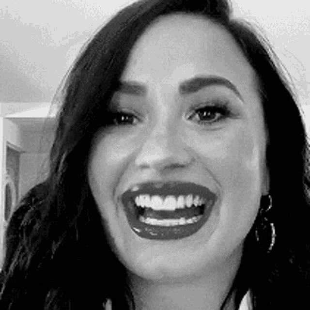 it is a black and white photo of a woman smiling .