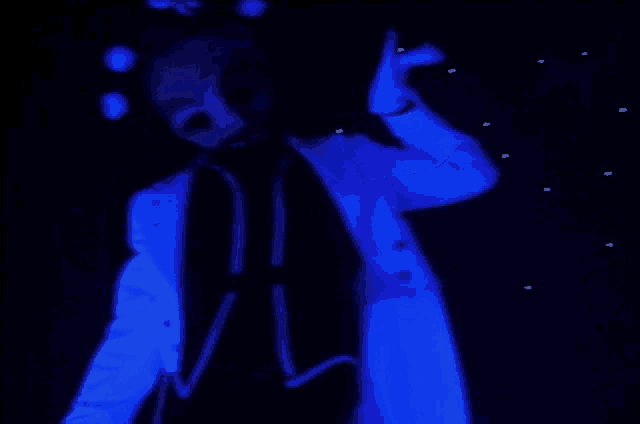 a person in a blue suit with a skull mask on their face