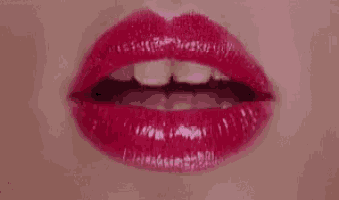 a close up of a woman 's mouth with red lipstick .