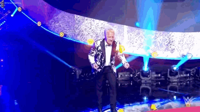 a man in a tuxedo and bow tie is on a stage