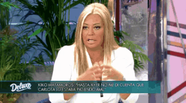 a woman in a white shirt is on a tv show called deluxe