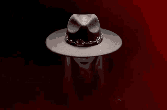 a person wearing a black hat with a chain around the brim
