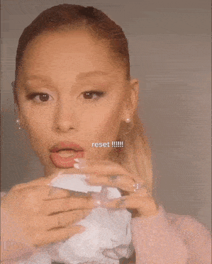 a woman is holding a tube of liquid lipstick in her hands
