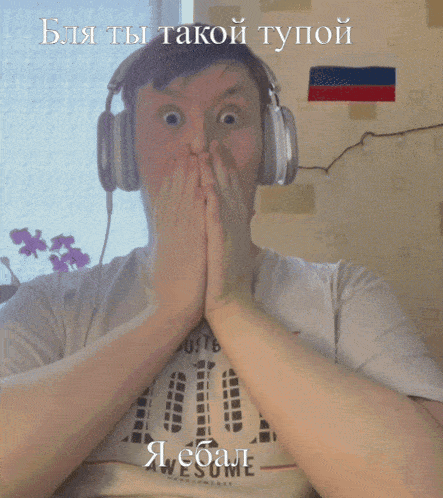 a man wearing headphones and a shirt that says awesome covers his mouth with his hands