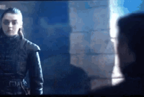 a man and a woman are standing next to each other and looking at each other .