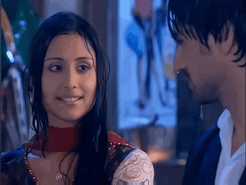 a man and a woman are looking at each other and the woman is smiling .