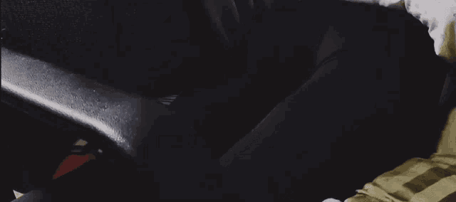 a person laying on a bed with a black chair