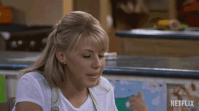 a woman sitting in front of a counter with a netflix logo on it