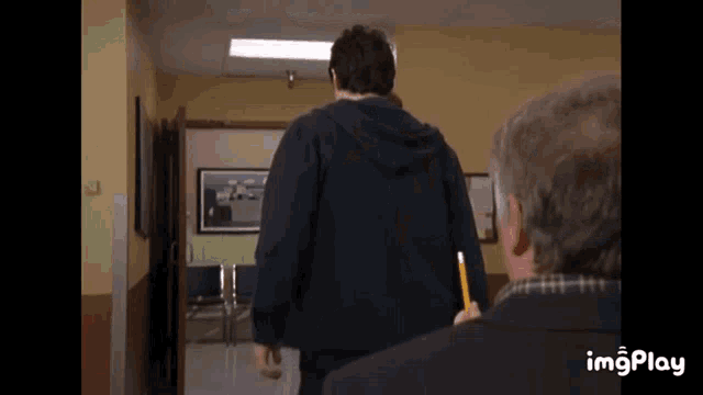 a man in a black hoodie is holding a pencil