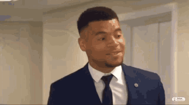a man in a suit and tie is standing next to a door .