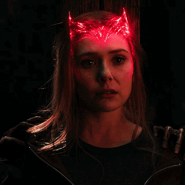 a close up of a woman 's face with a red light on her head