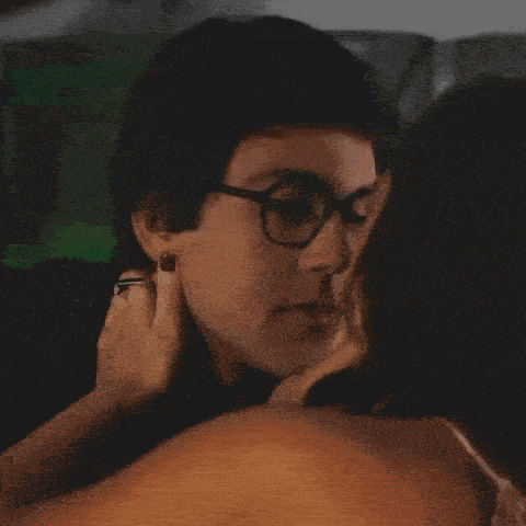 a man wearing glasses is being touched by a woman wearing a ring