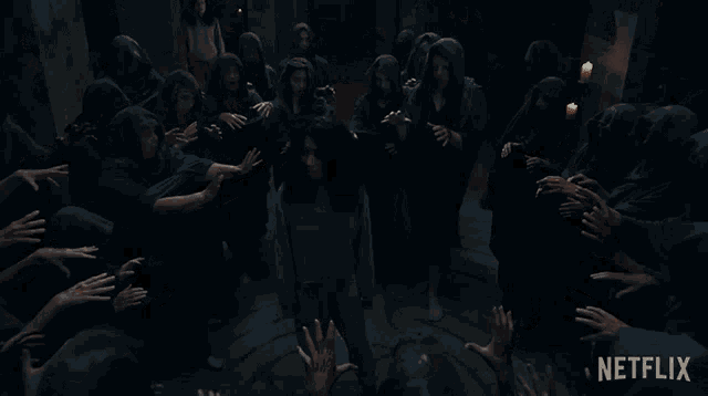 a woman is being attacked by a group of people in a dark room in a movie theater .
