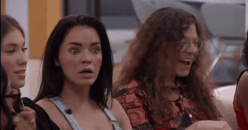 a group of women are sitting next to each other and one of them is making a surprised face