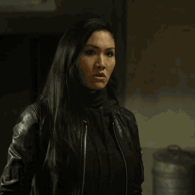 a woman wearing a black leather jacket and a black turtleneck