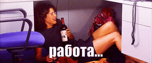 a woman is sitting under a desk holding a bottle of wine and a glass of wine and says " работа " in russian