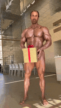 a naked man holds a gift box with a red bow