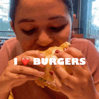 a woman is eating a hamburger with the words i love burgers behind her