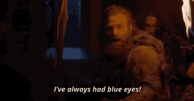 a man with a beard is holding a torch and saying i 've always had blue eyes .