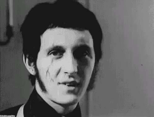 a black and white photo of a man wearing a tuxedo and bow tie with a scar on his face .