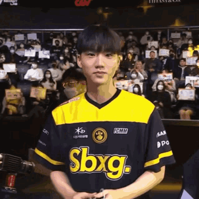 a man wearing a yellow and black sbxg jersey