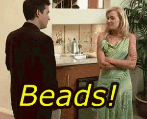 a woman in a green dress is standing next to a man in a suit with the words beads written on the screen