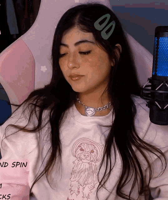 a girl wearing a white shirt with a dog on it is sitting in front of a pink chair with the words end spin on the bottom