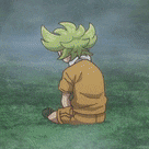 a boy with green hair is kneeling down in the grass .