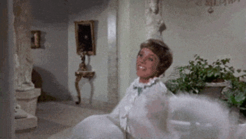 a woman in a white dress is sitting on a chair in a room .