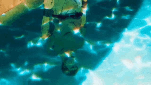 a person is swimming upside down in a pool of water