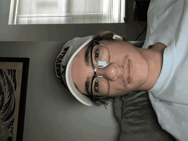a young man wearing glasses and a hat that says thrasher on it