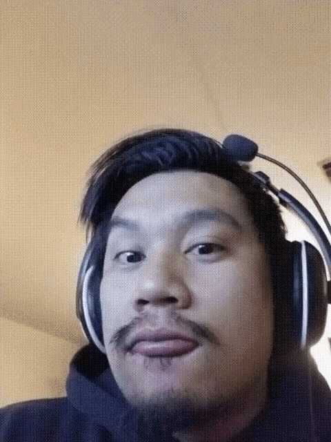 a man with a beard wearing headphones with a microphone on his head