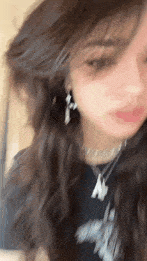 a close up of a woman 's face with a nose ring and earrings .