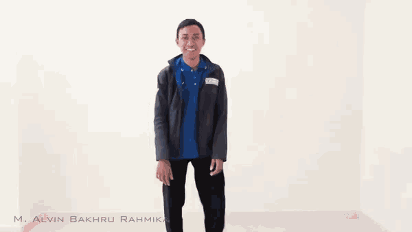 a man in a blue shirt and black pants is dancing in a white room .