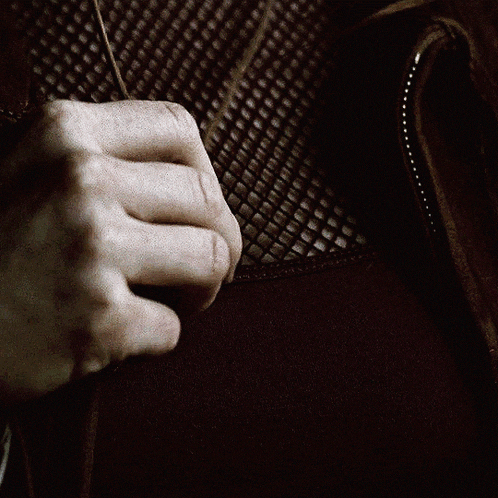 a person is holding a necklace with a pentagram pendant