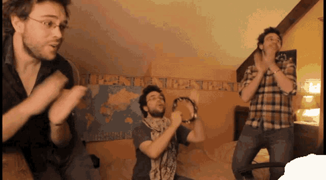 a group of men are dancing in front of a wall with a map of the world behind them