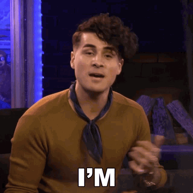 a man says i 'm while wearing a brown sweater and a blue scarf