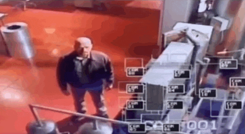 a man is standing in a room with a red floor and a camera .