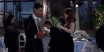 a man and a woman are standing next to each other in a room at a party .