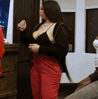a woman in a black bra and red pants is dancing